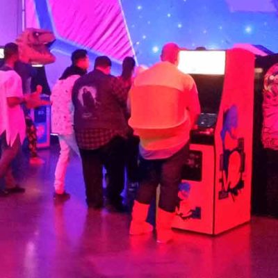 Company hosted Retro Party with Classic Arcades with costumed guest of Pacman playing a Pac Man Arcade Game