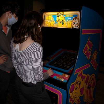 College Student Playing Ms Pacman arcade machine