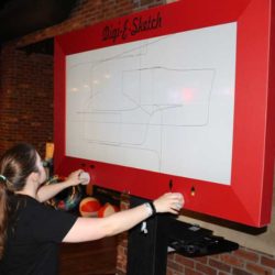 Girl playing Giant Etch A Sketch like Game at Event